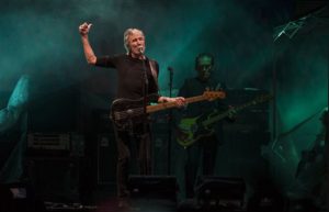 El cantante británico Roger Waters toca el bajo mientras ofrece un concierto gratuito en el Zócalo de la ciudad de México, la noche del sábado 1 de octubre de 2016. (AP Foto/Christian Palma)